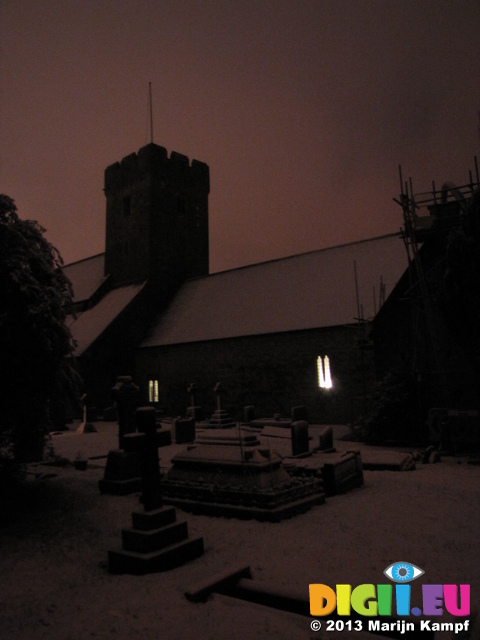 SX25885 Snow covered OId St Illtud's Church with lights on Llantwit Major